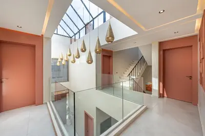 a glass staircase in a house with orange walls at Villa Nabil by TheCasaEdition Cinema, Heated pool & Jaccuzi in Marrakech