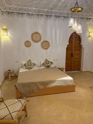a bedroom with a bed and a chandelier at Riad Amanar in Marrakech