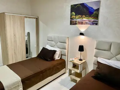 a small bedroom with two beds and a lamp at Cosy appartement near to airport in Marrakech