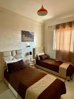 a bedroom with two beds and a window at Cosy appartement near to airport in Marrakech