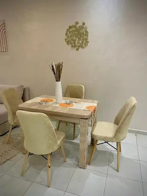 a dining room table with chairs and a vase on it at Cosy appartement near to airport in Marrakech