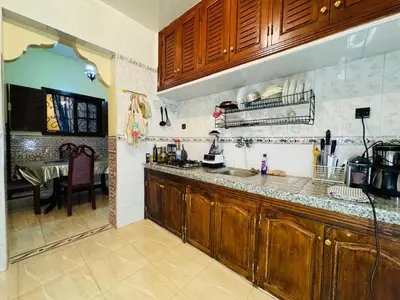 a kitchen with wooden cabinets and a table in it at Cozy room in marrakech in Marrakech