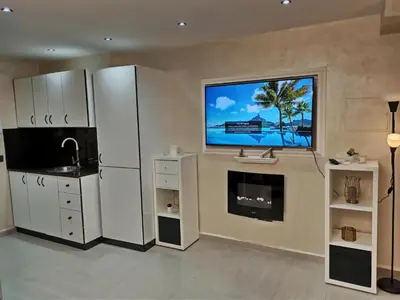 a kitchen with a refrigerator and a tv on the wall at Splendid One Bedroom center of Marrakech -Gueliz- in Marrakech