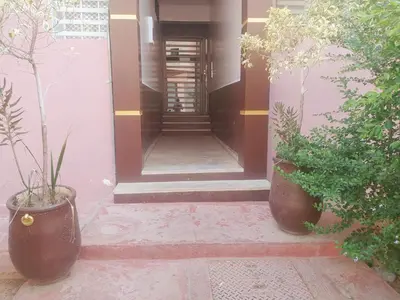 a front door of a house with two potted plants at Apartment Targa Reserved for Families in Marrakech