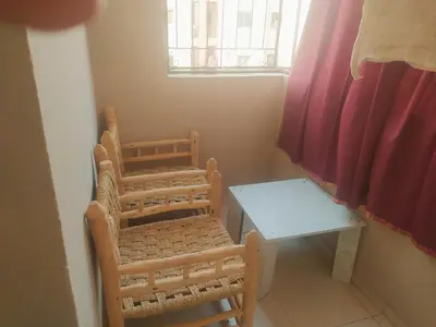 a small table and chairs in a room with a window at Apartment Targa Reserved for Families in Marrakech
