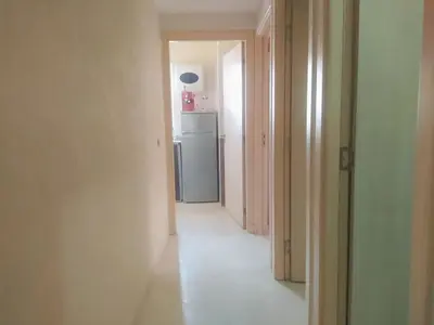 a hallway with a refrigerator in a white room at Apartment Targa Reserved for Families in Marrakech