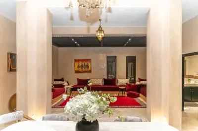 a living room with red couches and a table at Villa riad raffinée privée à Marrakech in Marrakech