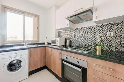 a kitchen with a sink and a washing machine at Luxury Appartement Golf and Pool in Marrakech