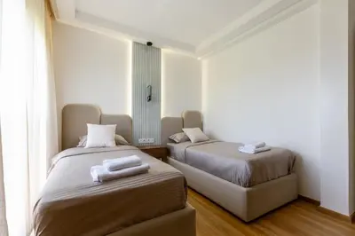two beds in a room with white walls and wood floors at Élégance et confort 3 chambre sur le golf de Noria in Marrakech