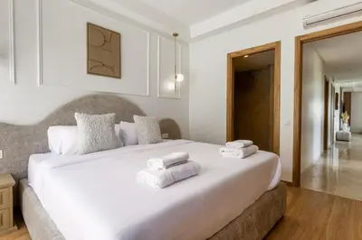 a bedroom with a large white bed with towels on it at Élégance et confort 3 chambre sur le golf de Noria in Marrakech