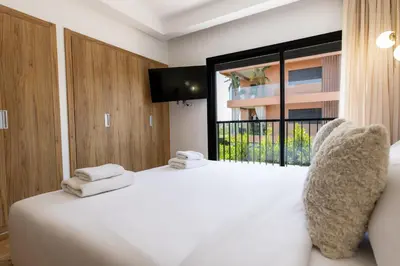 a bedroom with a white bed and a large window at Élégance et confort 3 chambre sur le golf de Noria in Marrakech