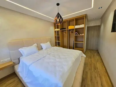 a bedroom with a large bed with white sheets at Appartement avec piscine in Marrakech