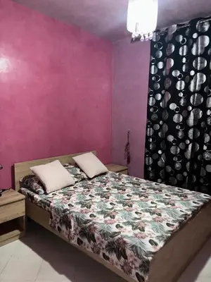 a bedroom with a bed and a purple wall at 2 bedroom apartment with Moroccan living room in Allal El Fassi in Marrakech