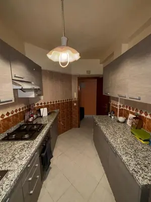 a kitchen with granite counter tops and a stove at 2 bedroom apartment with Moroccan living room in Allal El Fassi in Marrakech