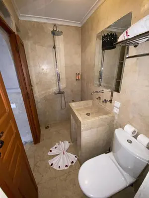 a bathroom with a white toilet and a sink at Riad Bab Yacout & SPA in Marrakech