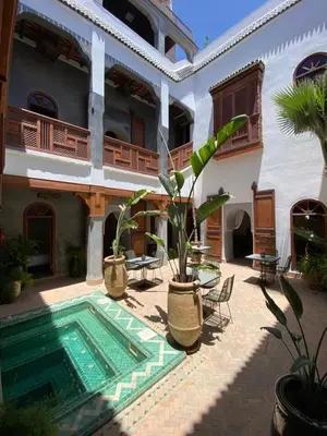 a courtyard with a swimming pool in a house at Riad Bab Yacout & SPA in Marrakech