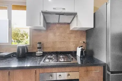 a kitchen with a stove top and white cabinets at Nice apartment in Marrakesh in Marrakech