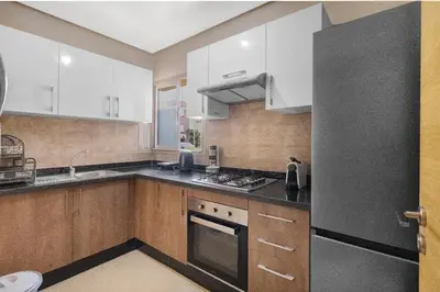 a kitchen with white cabinets and a black refrigerator at Nice apartment in Marrakesh in Marrakech