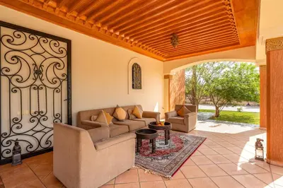 a living room with a couch and a table at Taj Palmeraie Palace Marrakech in Marrakech
