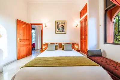 a bedroom with a large bed and a couch at Taj Palmeraie Palace Marrakech in Marrakech