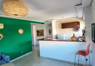 a kitchen with a counter and a green wall at Séjour Arty et Confort à Marrakech in Marrakech