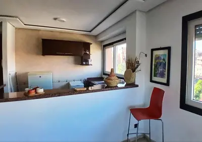 a kitchen with a red chair and a counter at Séjour Arty et Confort à Marrakech in Marrakech