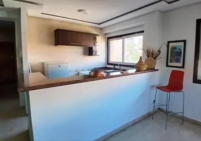a kitchen with a counter and a red stool at Séjour Arty et Confort à Marrakech in Marrakech
