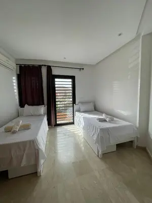 a room with two beds and a window at Appartement Centre Ville Gueliz Parking Inclus in Marrakech
