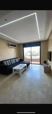 a living room with a couch and a table at Appartement Centre Ville Gueliz Parking Inclus in Marrakech
