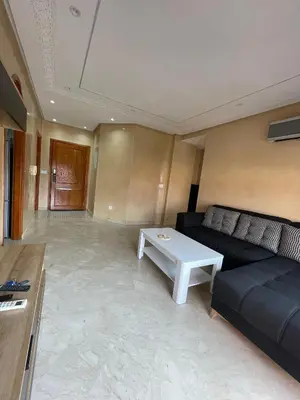 a living room with a couch and a table at Appartement Centre Ville Gueliz Parking Inclus in Marrakech
