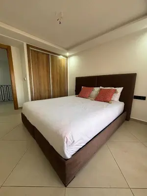 a bedroom with a large bed with red pillows at Elegant Duplex 2 chambres in Marrakech