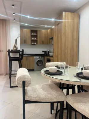 a dining room with a table and chairs and a kitchen at Elegant Duplex 2 chambres in Marrakech