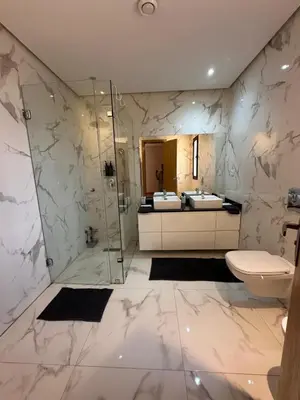 a bathroom with a toilet and a glass shower at Villa familiale a 10km du boulevard Mohamed VI in Marrakech