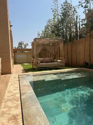 a gazebo sitting next to a swimming pool at Villa familiale a 10km du boulevard Mohamed VI in Marrakech