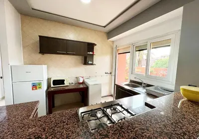 a kitchen with a sink and a stove top oven at Escapade citadine avec balcon et confort total in Marrakech