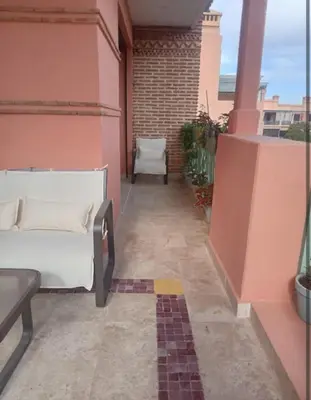 a balcony with a couch and a chair on a building at Appartement cosy moderne luxe in Marrakech
