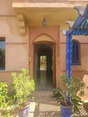 an entry way to a building with plants in pots at Villa Marrakech haut standing avec piscine et architecture arabesque in Marrakech