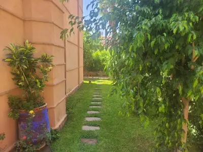 a garden with a walkway next to a building at Villa Marrakech haut standing avec piscine et architecture arabesque in Marrakech