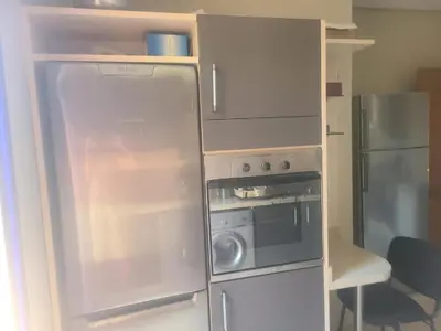 a small kitchen with a refrigerator and a stove at Villa Marrakech haut standing avec piscine et architecture arabesque in Marrakech