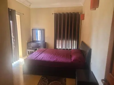 a bedroom with a purple bed and a tv at Villa Marrakech haut standing avec piscine et architecture arabesque in Marrakech