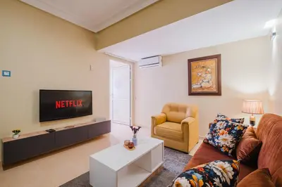 a living room with a couch and a tv and a chair at Appartement Relax & Confort au Cœur de Marrakech in Marrakech
