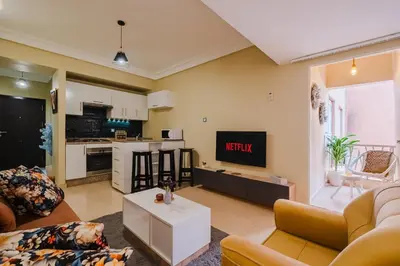 a living room with a couch and a tv at Appartement Relax & Confort au Cœur de Marrakech in Marrakech