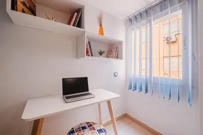 a laptop on a white desk in a room with a window at Appartement Relax & Confort au Cœur de Marrakech in Marrakech