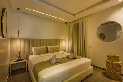 a bedroom with a large bed and a mirror at Sakina Appartement Luxe Gueliz in Marrakech