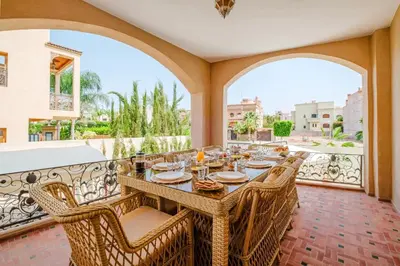 a patio with a table and chairs on a balcony at Very comfortable villa in the heart of Marrakech in Marrakech