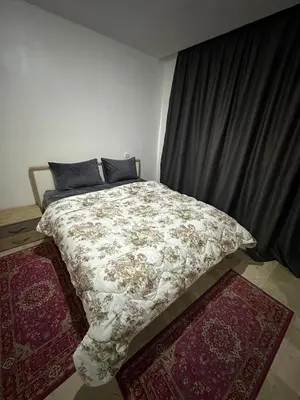 a bed in a room with two rugs at L'AUTHENTIQUE 37 face de la gare CTM Hivernage in Marrakech