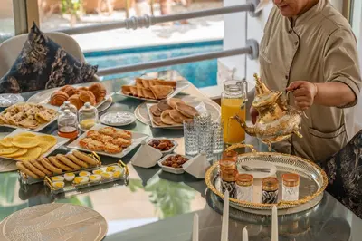 a man standing in front of a table of food at M REVASION villa 5 chambres front de golf Petit déjeuner petit ménage et Tranfert aéroport inclus in Marrakech