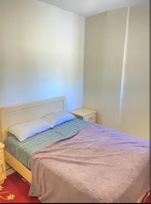 a bedroom with a bed with a purple blanket at Moroccorent in Marrakech