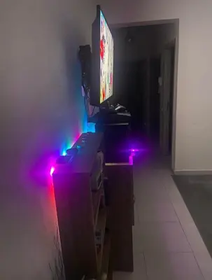 a room with a tv on a table with purple lights at Moroccorent in Marrakech