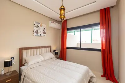 a bedroom with a bed and a window with red curtains at Elegance and Comfort in Marrakesh in Marrakech